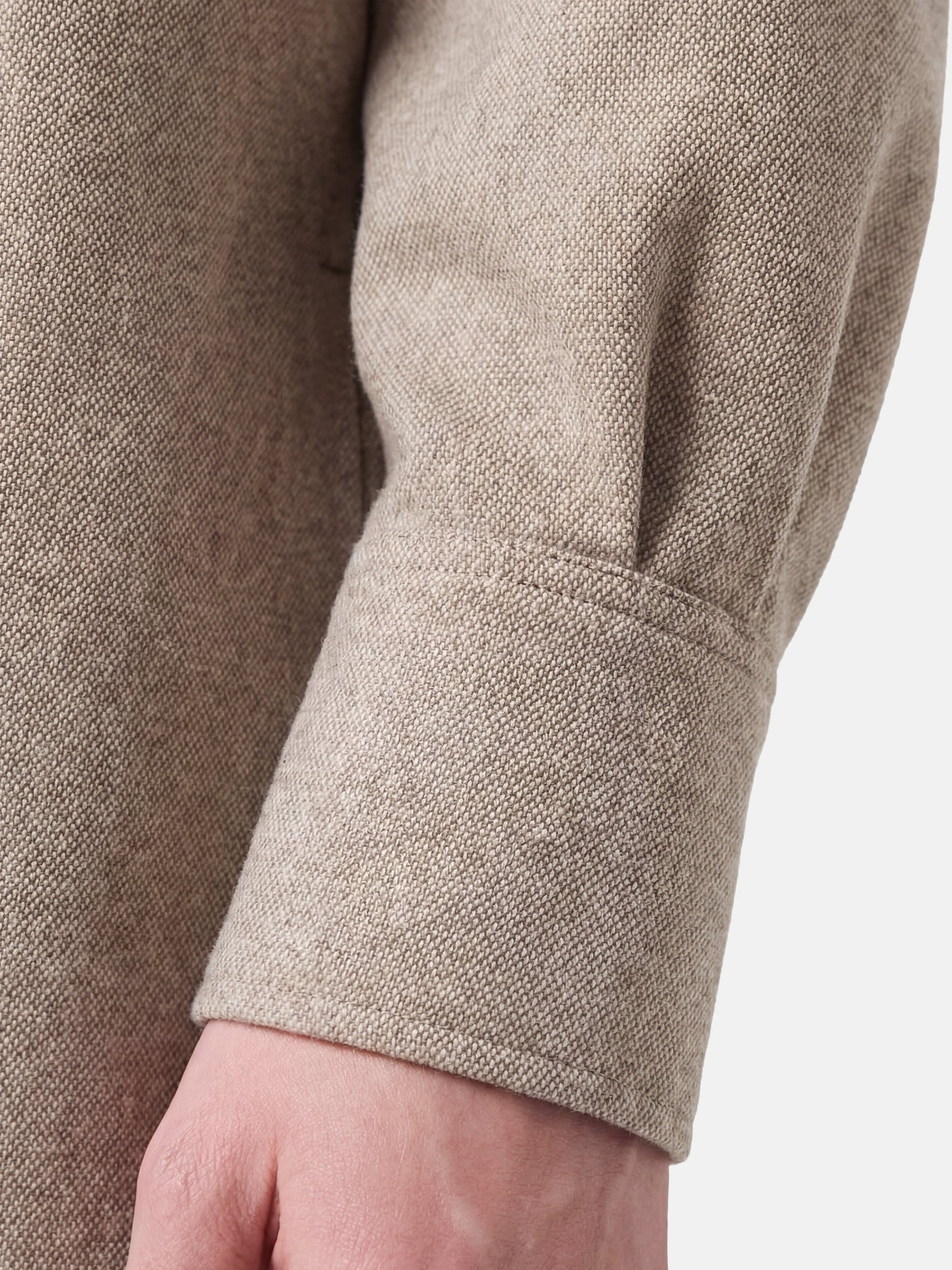 Muted apricot structured top by SELVANE, featuring a clean front seam, sculpted cuffs, and a detachable contrast scarf detail.