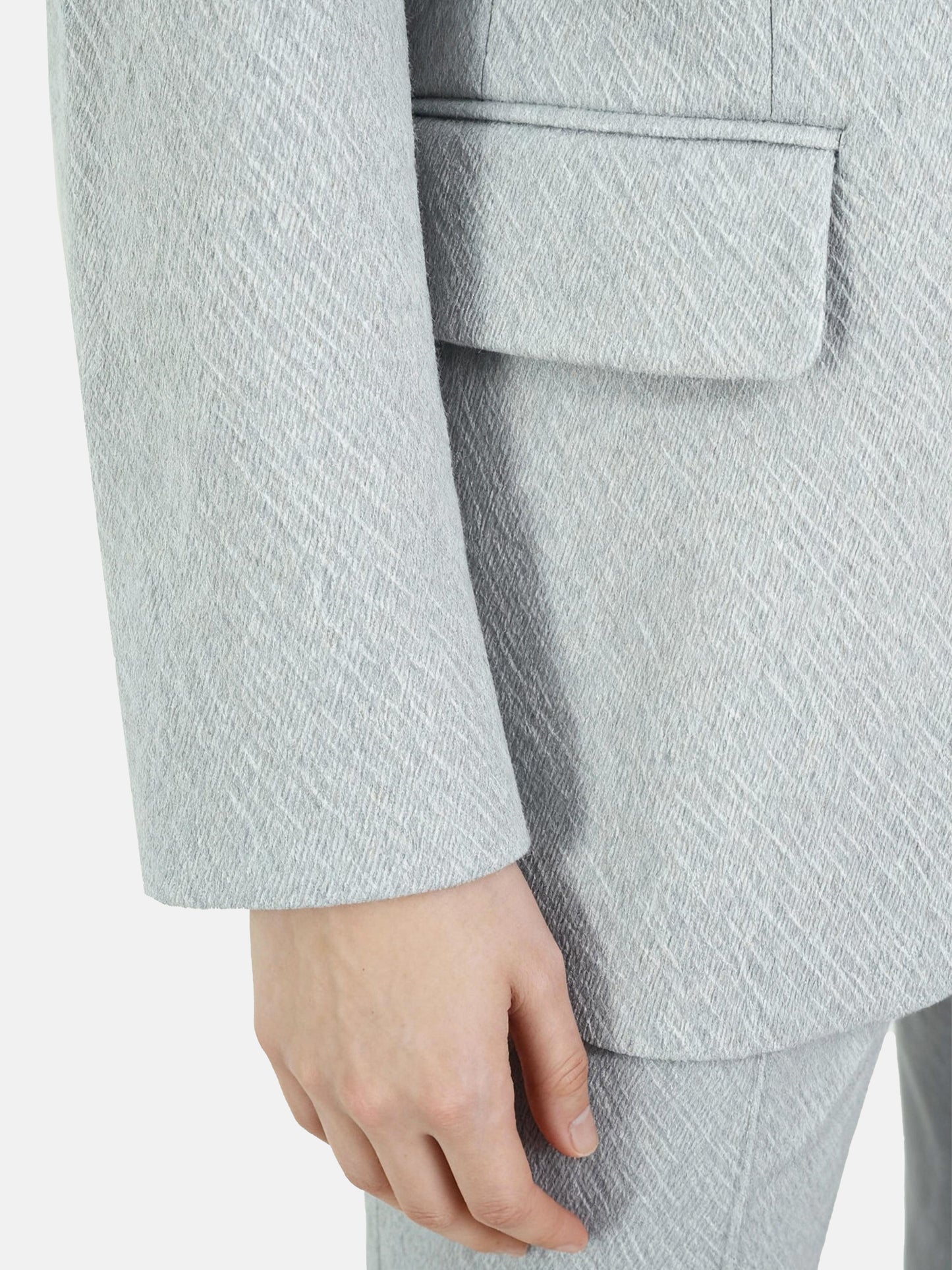 Structured worsted wool jacket with mulberry silk lining, tailored fit, shown on a model in a thoughtful pose.