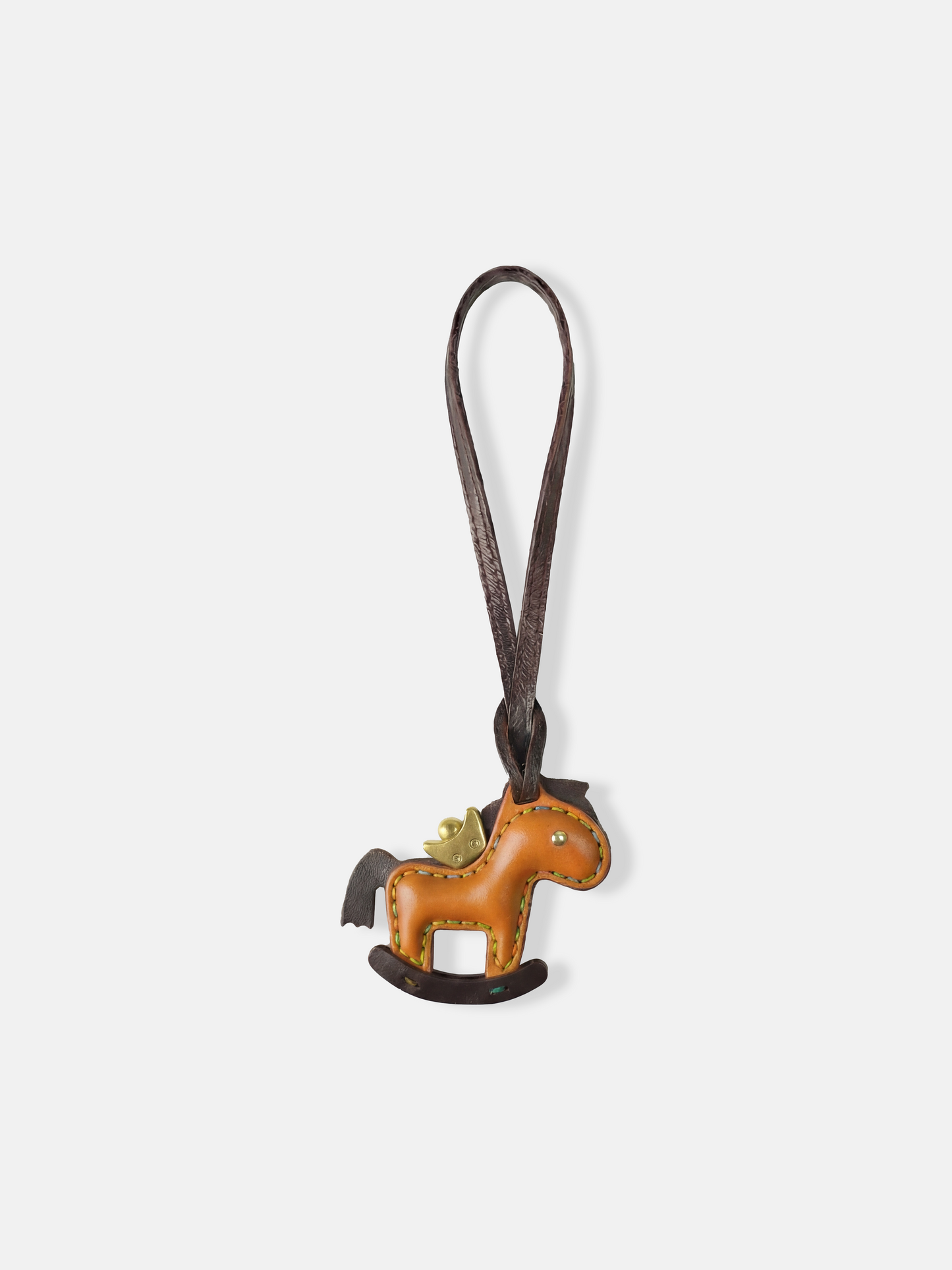 Deep green leather rocking horse bag charm with a gold-tone crown, compact and graphic, attached to a bag.