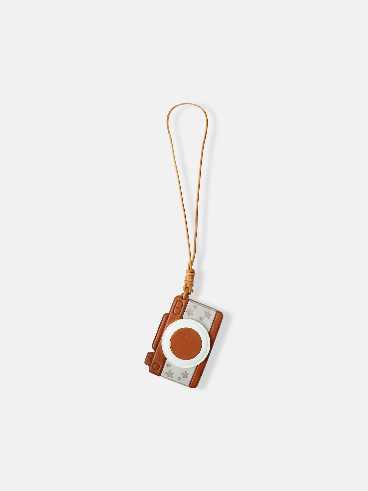Selvane Retro Camera Bag Charm featuring a graphic, pocket-size silhouette with a bold circular lens, squared edges, and playful star detailing, attached to a long strap.