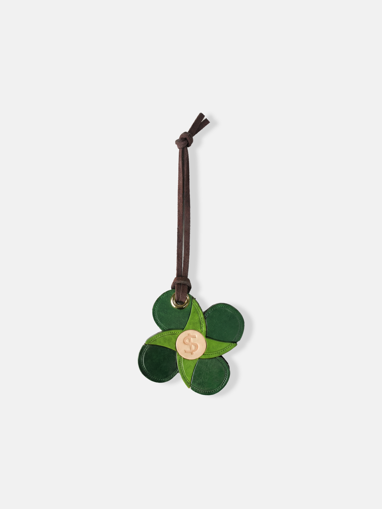 Selvane Lucky Four-Leaf Clover Bag Charm, soft leather, graphic four-petal silhouette, coin center, elegant leather tie. Symbolizes luck.