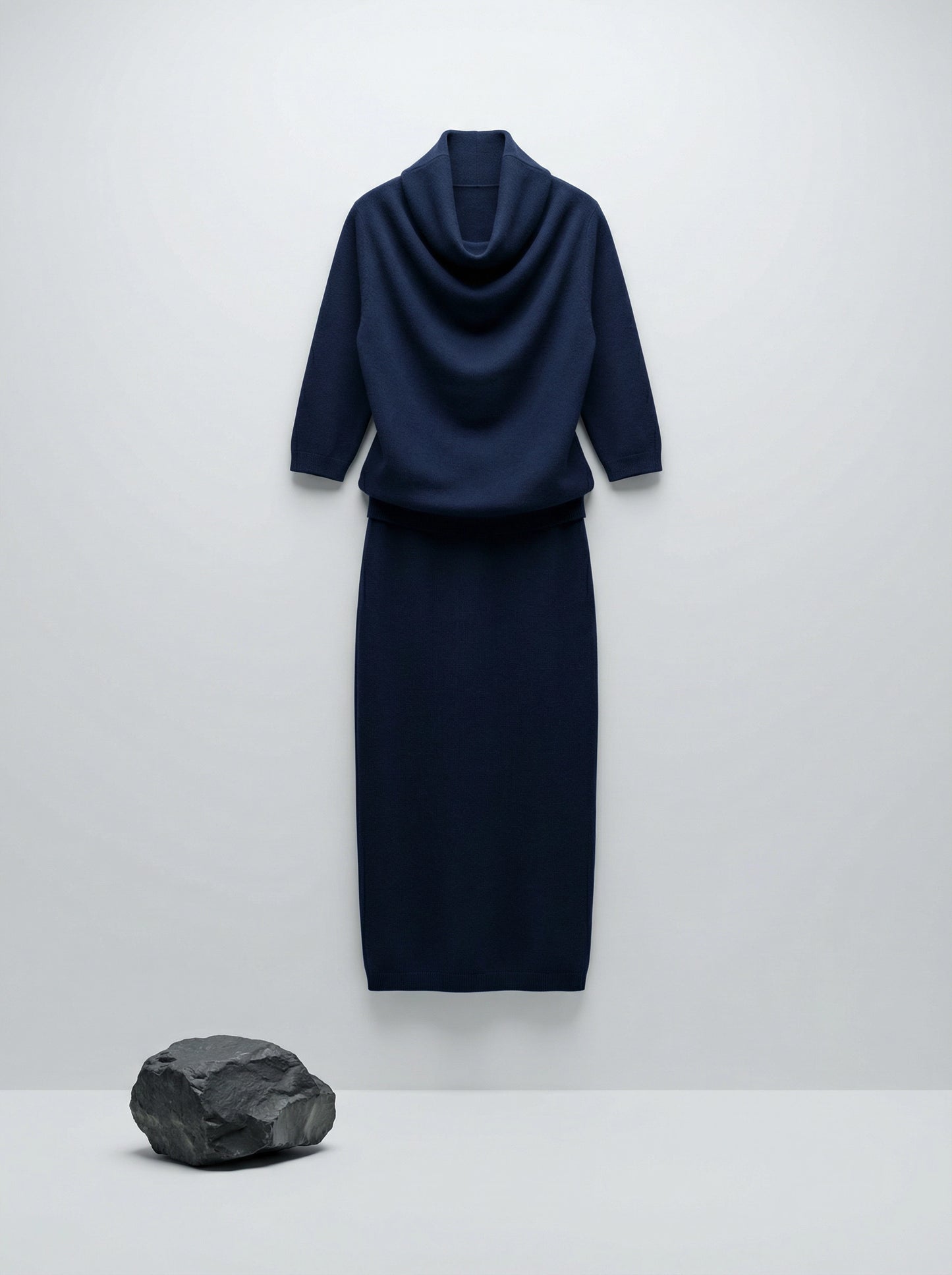 Model wearing a deep navy Tencel-blend cowl-neck top and matching midi pencil skirt set, styled elegantly.
