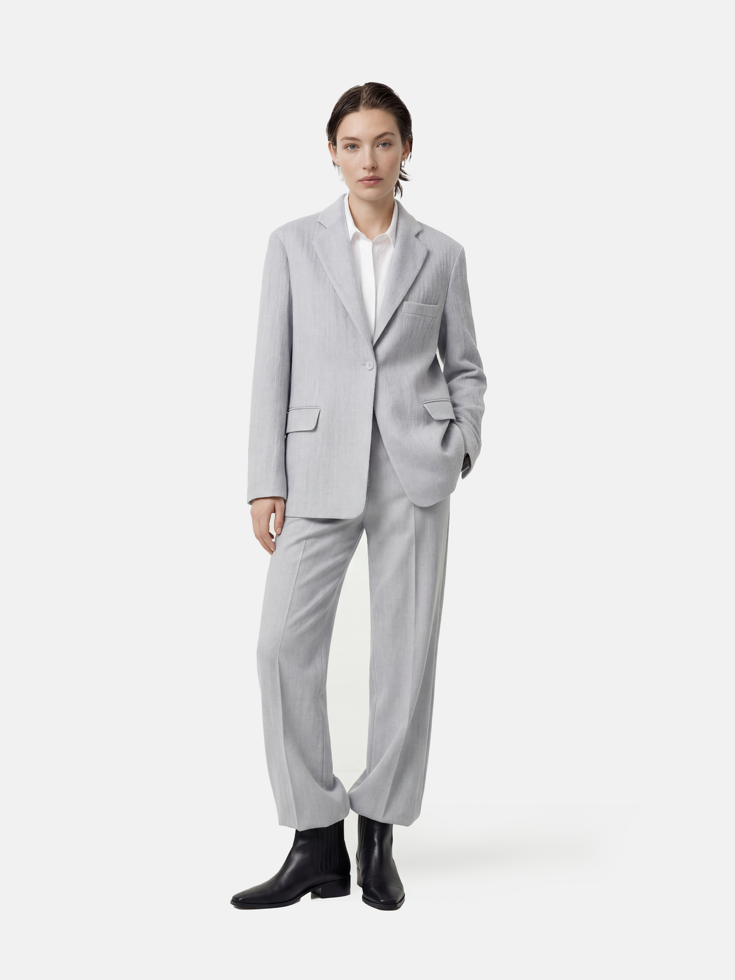 Structured worsted wool jacket with mulberry silk lining, tailored fit, shown on a model in a thoughtful pose.