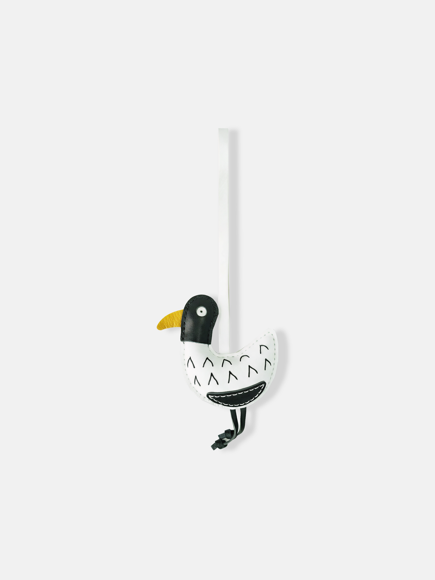 Selvane Little Bird Bag Charm with a long strap, compact yellow bird body, contrast head, curved belly, and slender hanging legs, against a neutral background.
