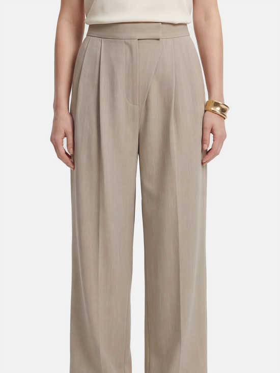 Cropped wide-leg trousers in quiet khaki, featuring deep pleats and an asymmetric front, embodying architectural form and fluid motion.