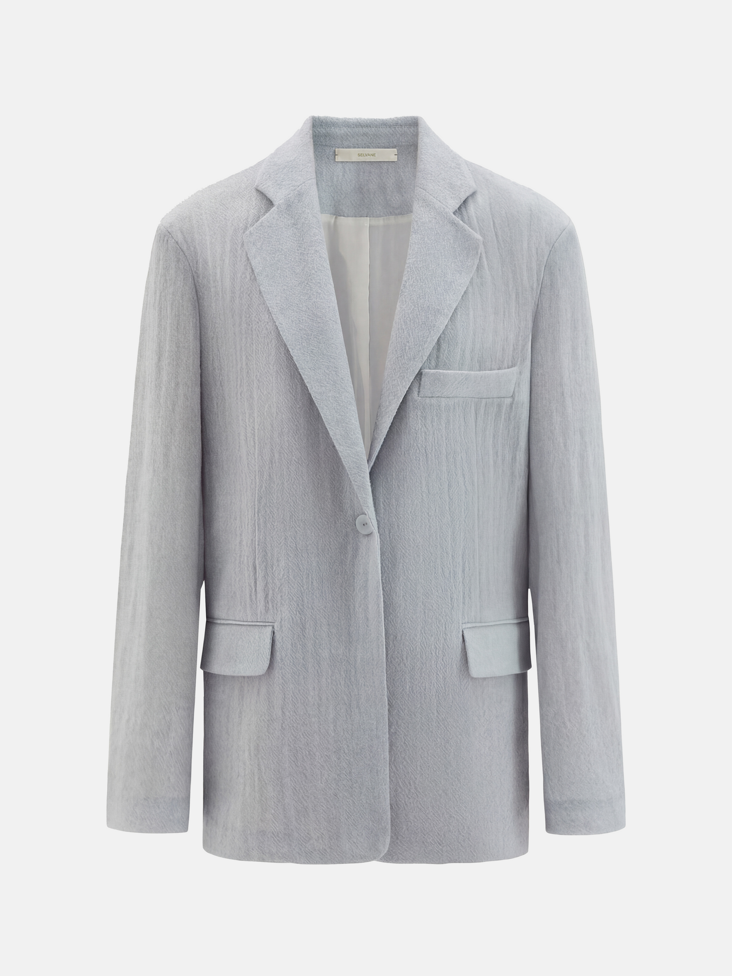 Structured worsted wool jacket with mulberry silk lining, tailored fit, shown on a model in a thoughtful pose.