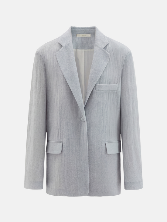 Structured worsted wool jacket with mulberry silk lining, tailored fit, shown on a model in a thoughtful pose.