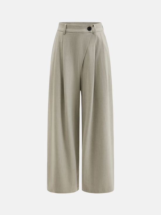 Cropped wide-leg trousers in quiet khaki, featuring deep pleats and an asymmetric front, embodying architectural form and fluid motion.