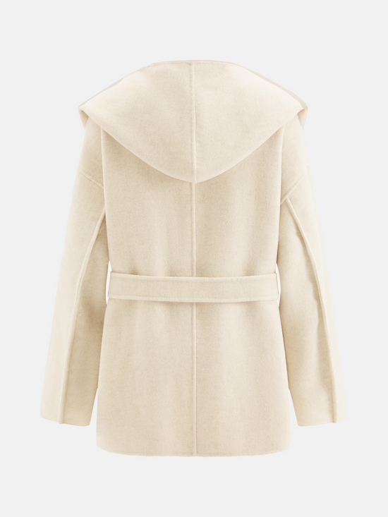 Full-length image of a cream wool belted overcoat with sculpted collar, self-tie belt, and oversized patch pockets, draped elegantly.