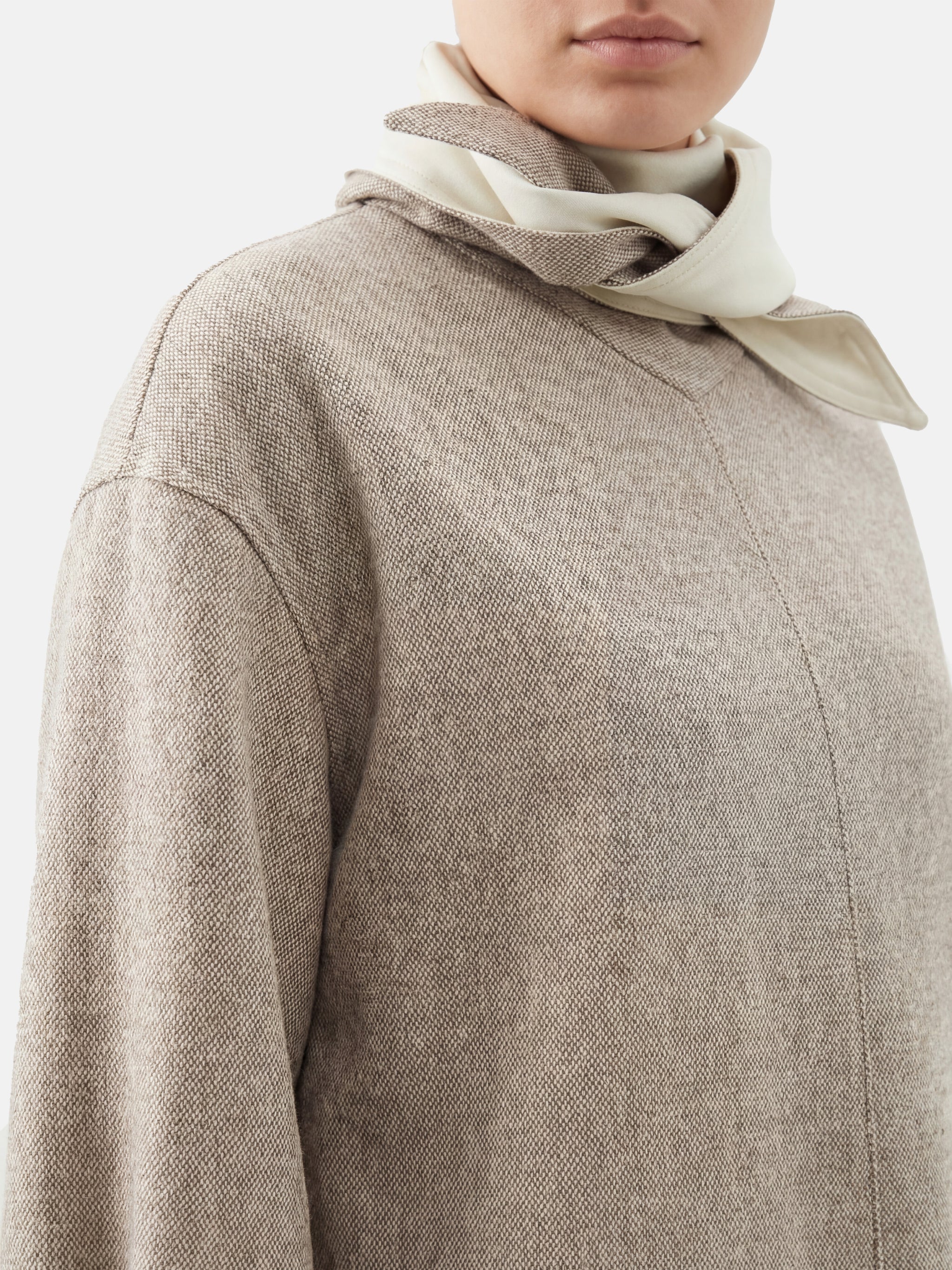 Muted apricot structured top by SELVANE, featuring a clean front seam, sculpted cuffs, and a detachable contrast scarf detail.