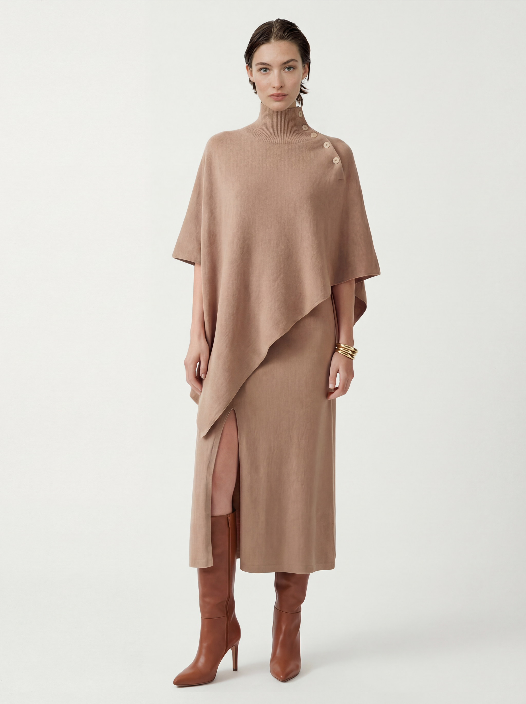 Pure cashmere button-neck cape in warm camel with an elongated, asymmetric drape and high ribbed neck.