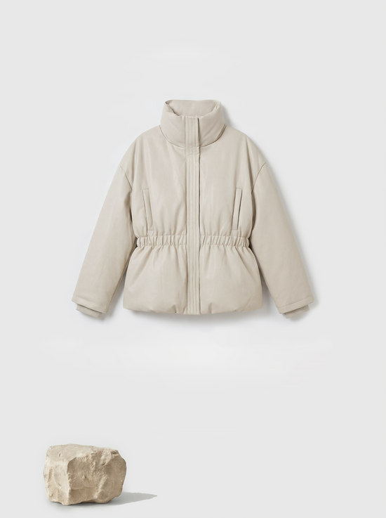 Apricot high-collar structured puffer down jacket by SELVANE, featuring a concealed placket and cinched waist, presented architecturally.