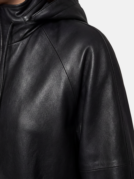 Deep black hooded lambskin zip jacket by SELVANE, featuring a soft utilitarian line and protective design for urban movement.