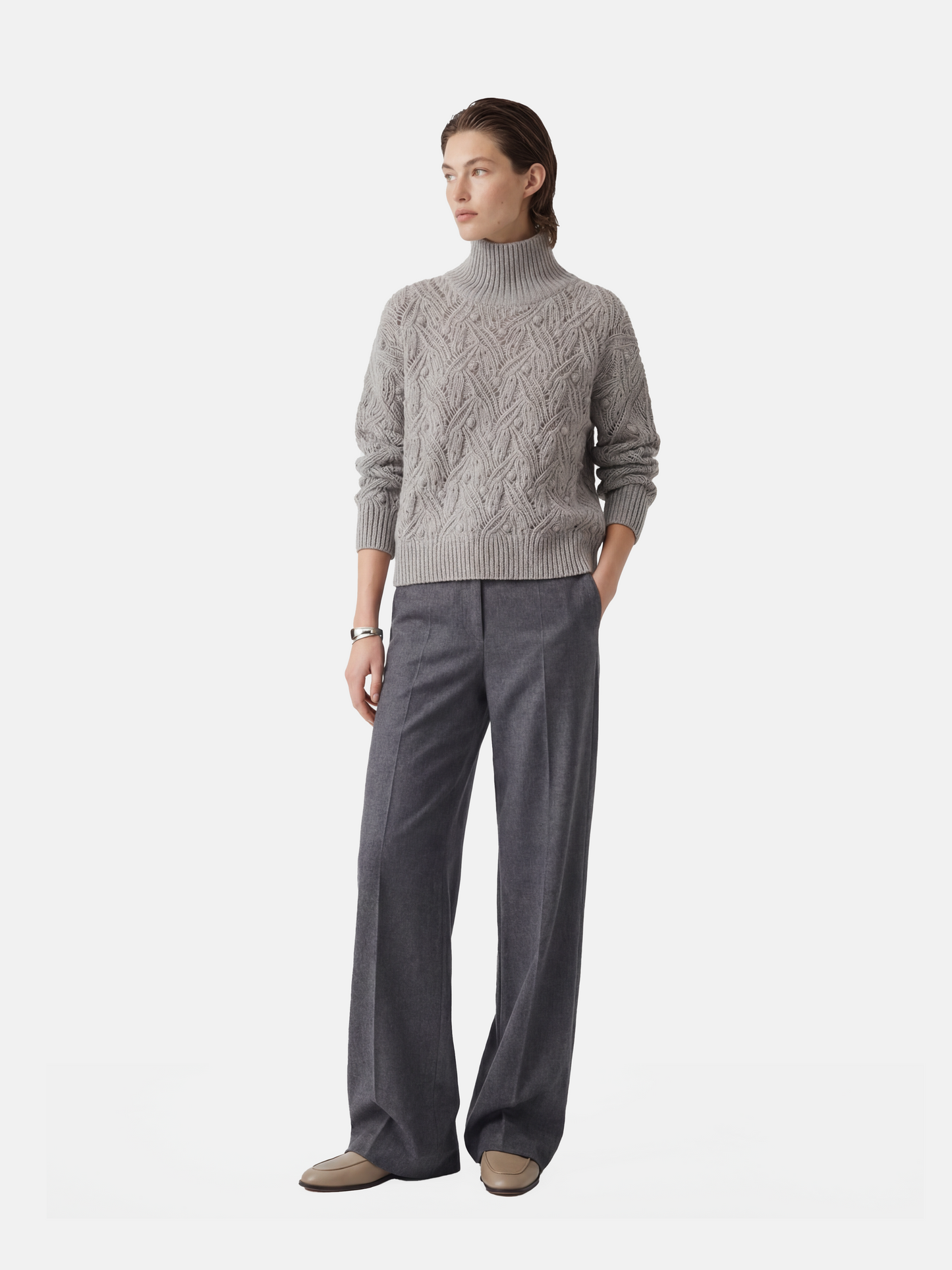 Cropped soft grey cashmere mock-neck cable sweater with sculpted texture, shown on a model, conveying quiet warmth and refined presence.