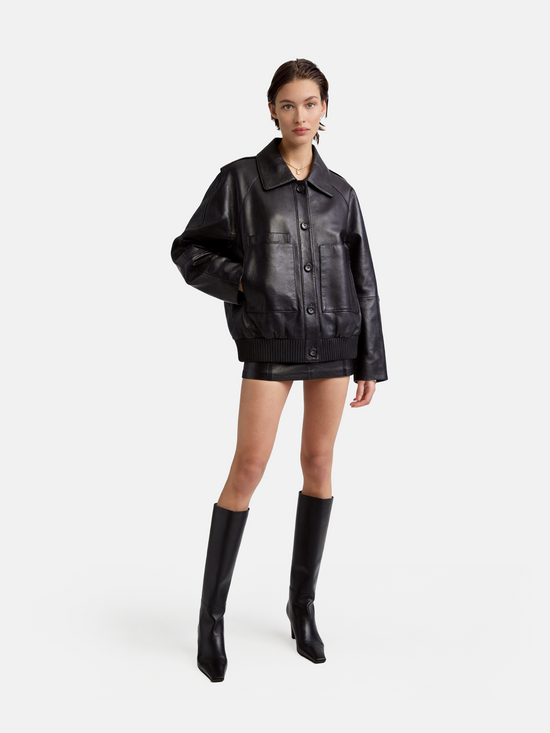 SELVANE deep black lambskin button bomber, cropped silhouette with ribbed hem and oversized patch pockets.