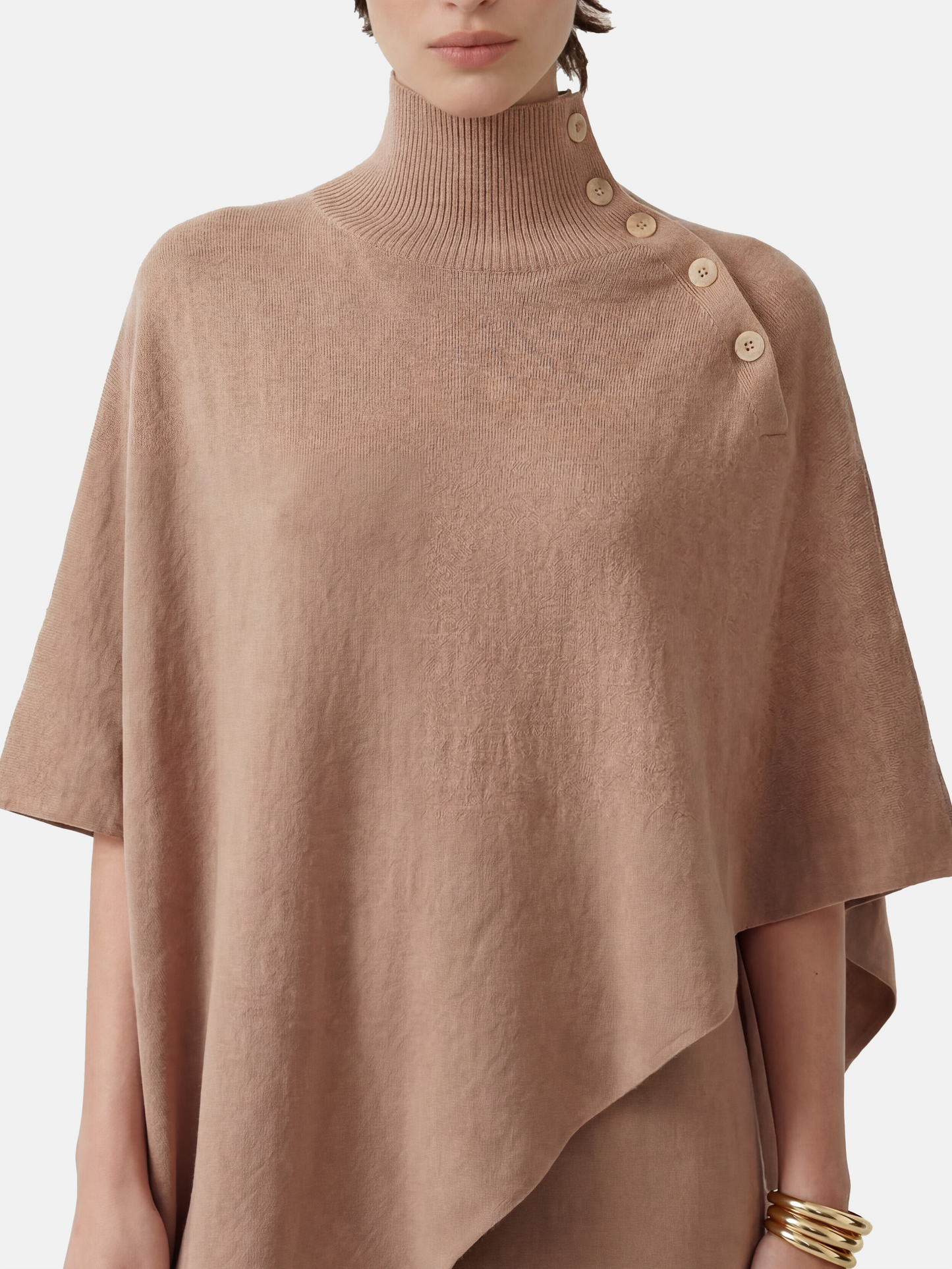 Pure cashmere button-neck cape in warm camel with an elongated, asymmetric drape and high ribbed neck.