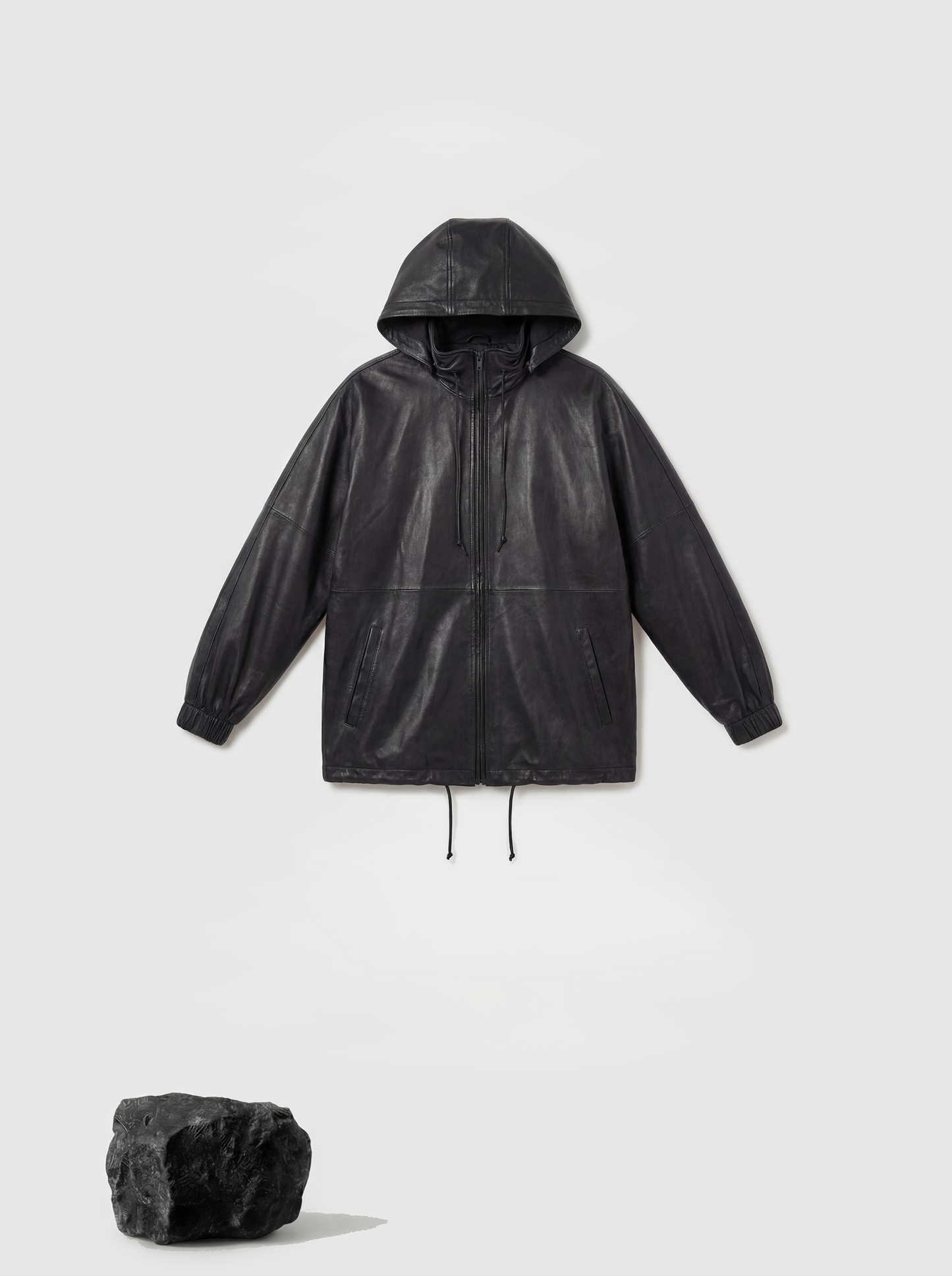 Deep black hooded lambskin zip jacket by SELVANE, featuring a soft utilitarian line and protective design for urban movement.