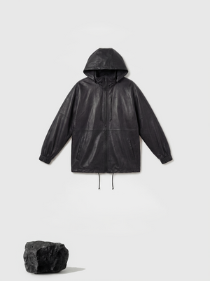 Deep black hooded lambskin zip jacket by SELVANE, featuring a soft utilitarian line and protective design for urban movement.
