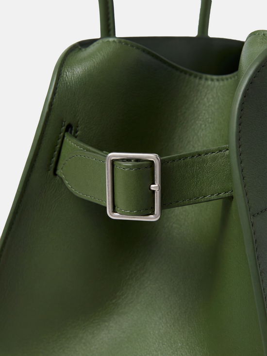 Structured deep navy saddle leather top handle bag with clean curves and elegant trapezoid shape.