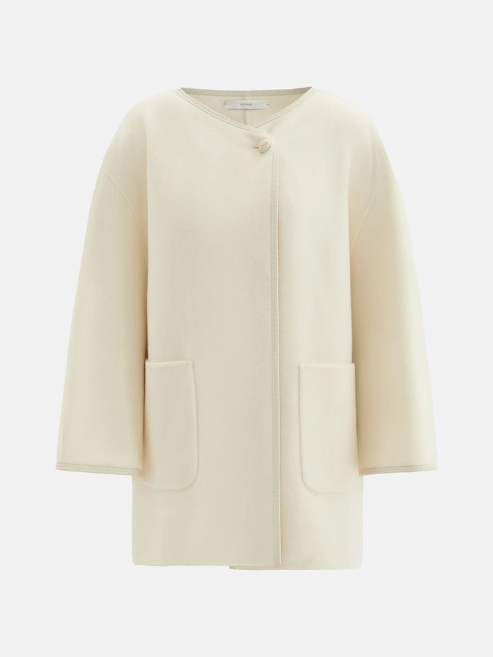 SELVANE asymmetric single-button wool coat in calm ivory, featuring a clear line and composed silhouette.