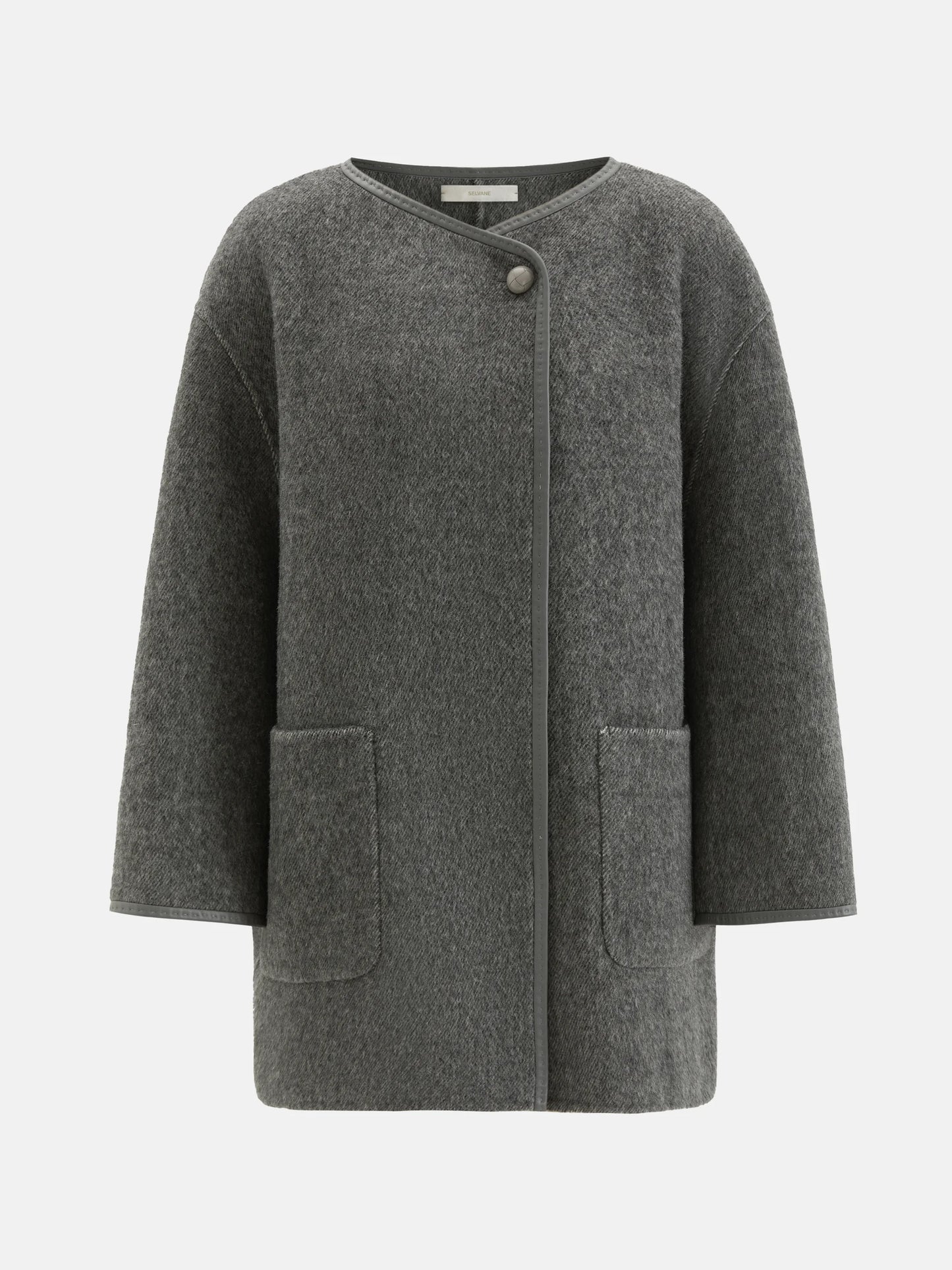 SELVANE asymmetric single-button wool coat in calm ivory, featuring a clear line and composed silhouette.