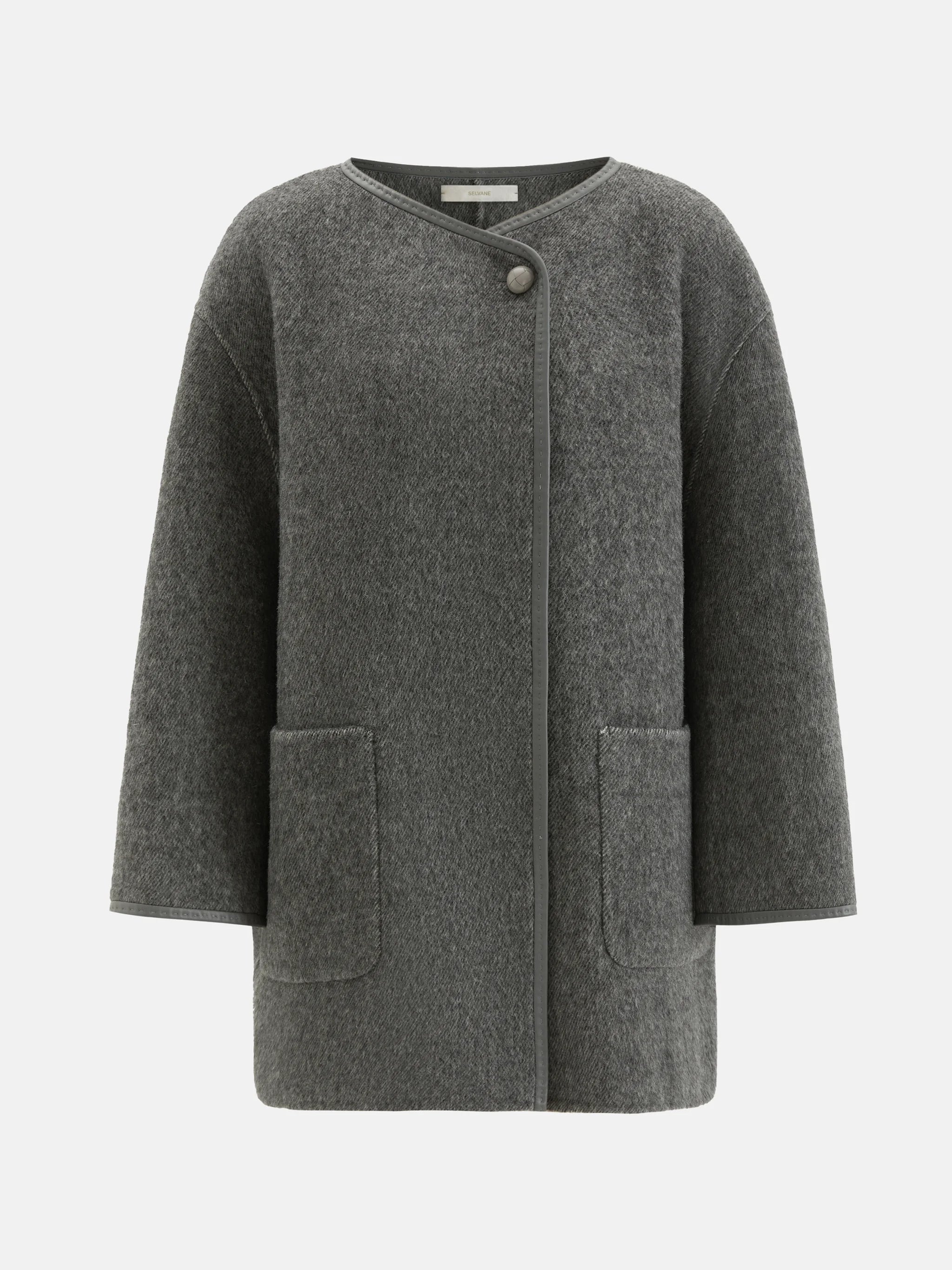 SELVANE asymmetric single-button wool coat in calm ivory, featuring a clear line and composed silhouette.