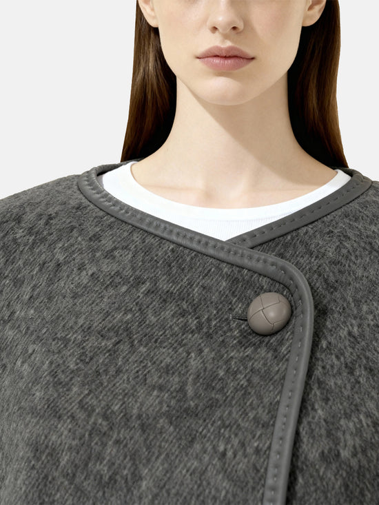SELVANE asymmetric single-button wool coat in calm ivory, featuring a clear line and composed silhouette.