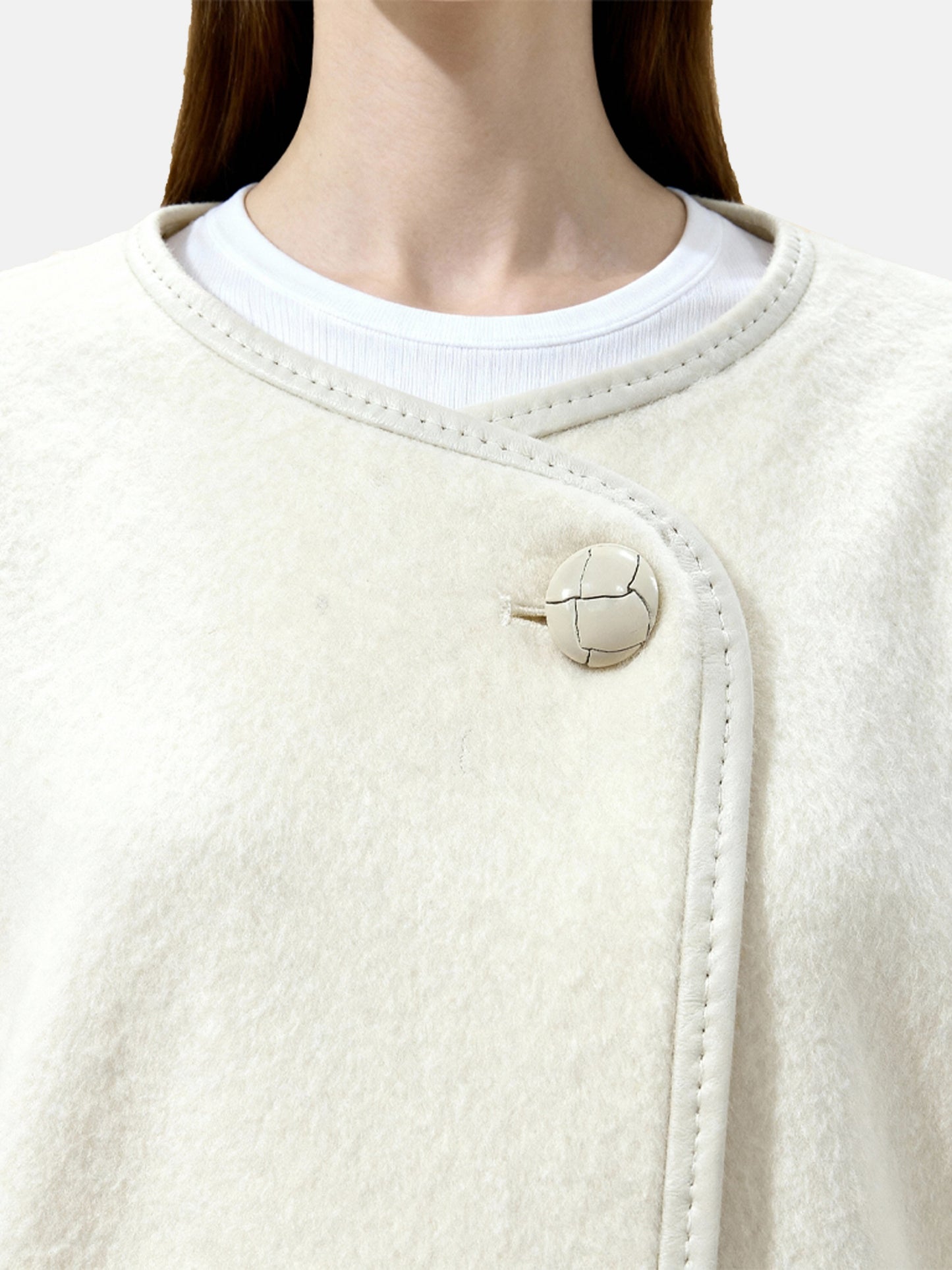 SELVANE asymmetric single-button wool coat in calm ivory, featuring a clear line and composed silhouette.