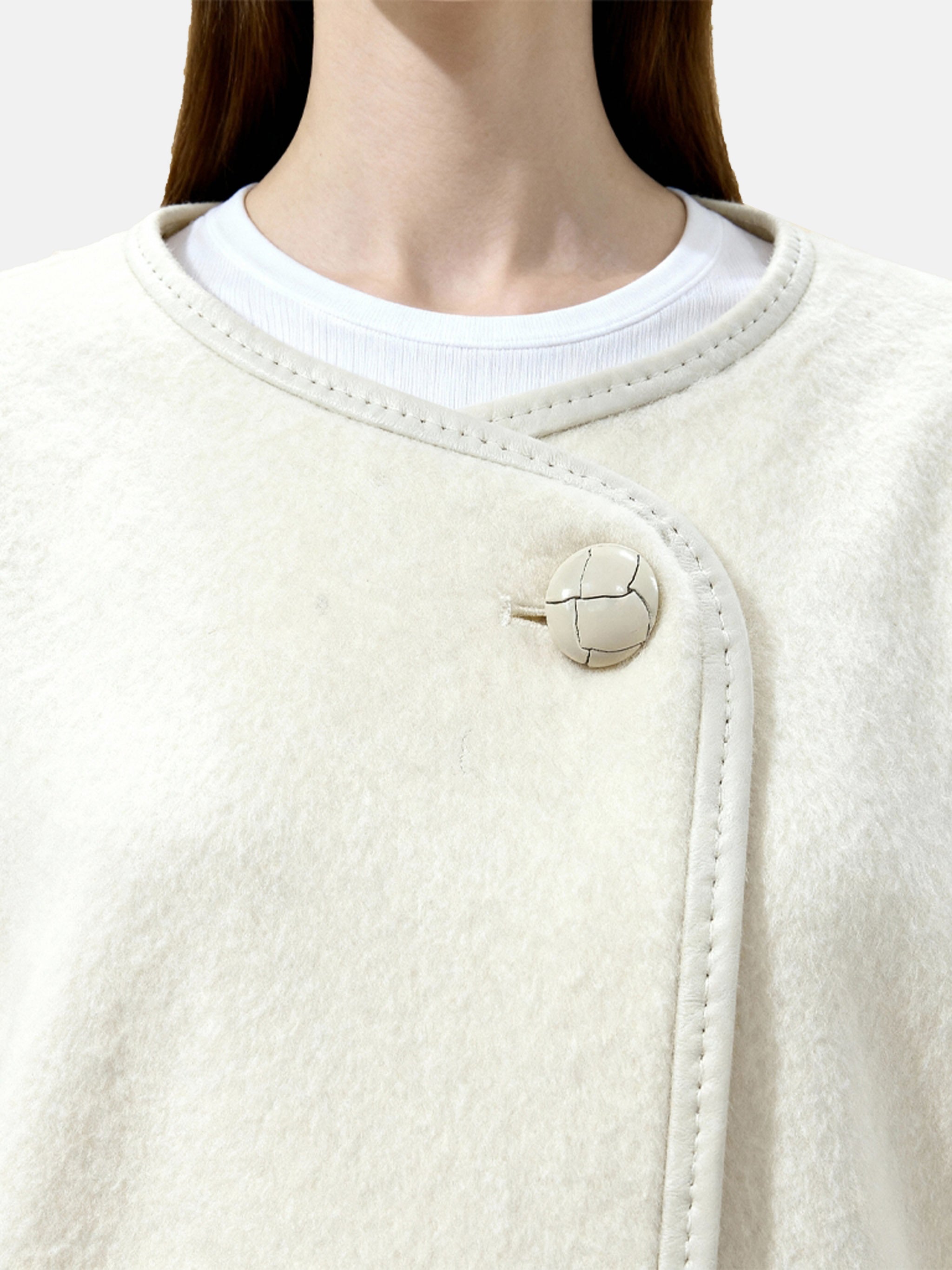 SELVANE asymmetric single-button wool coat in calm ivory, featuring a clear line and composed silhouette.
