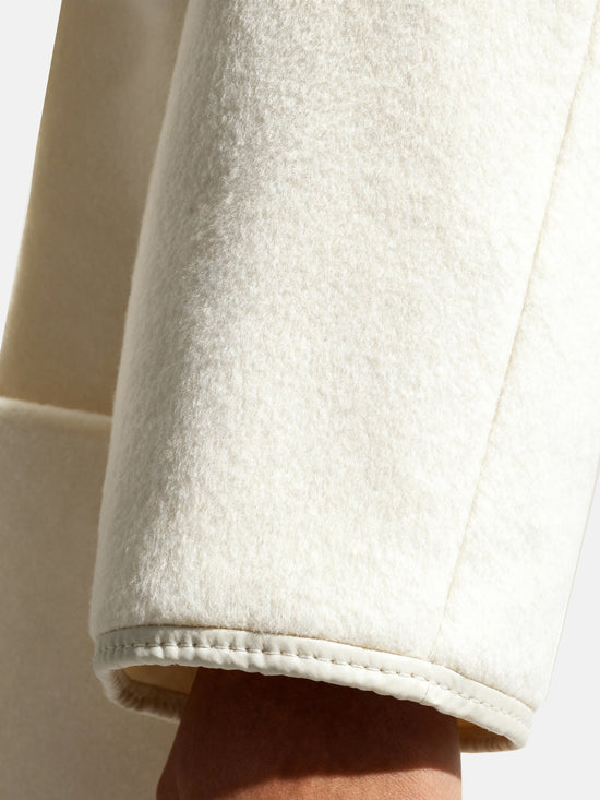 SELVANE asymmetric single-button wool coat in calm ivory, featuring a clear line and composed silhouette.