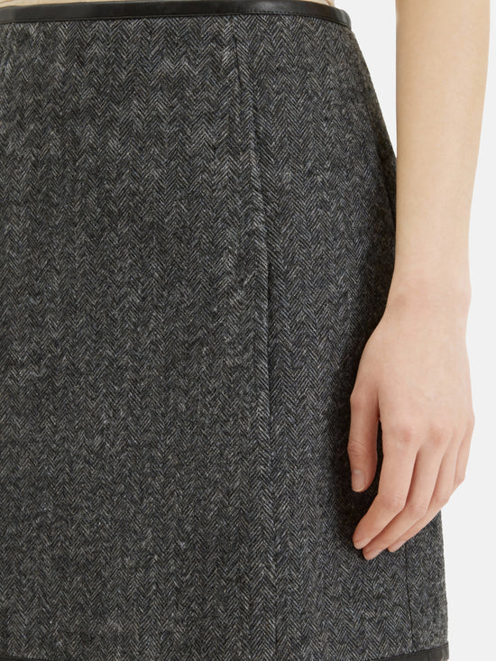 Charcoal wool-blend two-piece set featuring a cropped, boxy jacket with a sharp faux-leather contrast collar and a clean straight skirt.