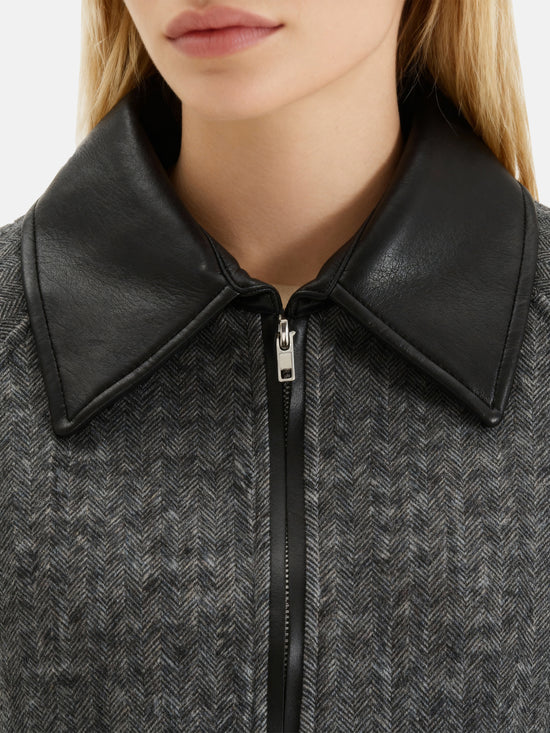 Charcoal wool-blend two-piece set featuring a cropped, boxy jacket with a sharp faux-leather contrast collar and a clean straight skirt.