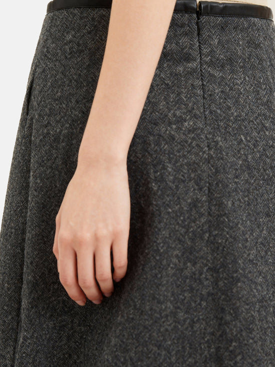 Charcoal wool-blend two-piece set featuring a cropped, boxy jacket with a sharp faux-leather contrast collar and a clean straight skirt.