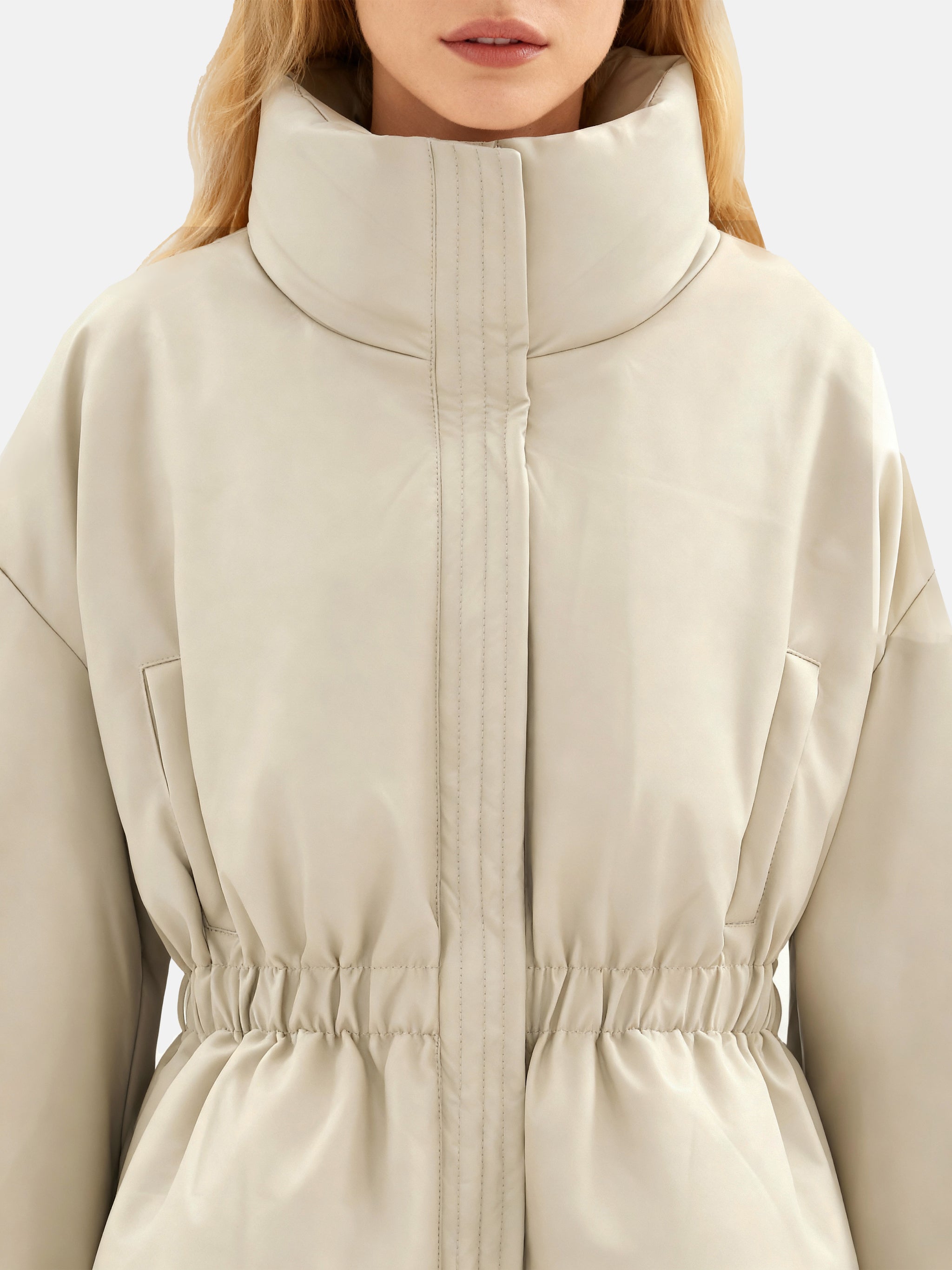 Apricot high-collar structured puffer down jacket by SELVANE, featuring a concealed placket and cinched waist, presented architecturally.