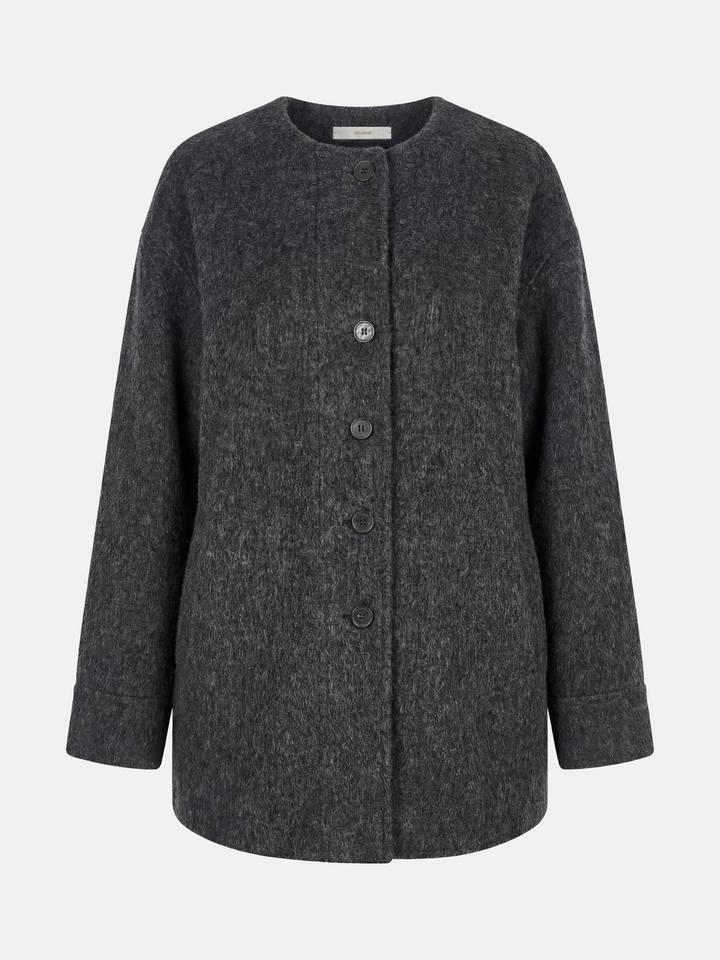 Beige wool and camel hair buttoned coat by SELVANE, featuring a rounded neck and minimal buttons, draped elegantly.