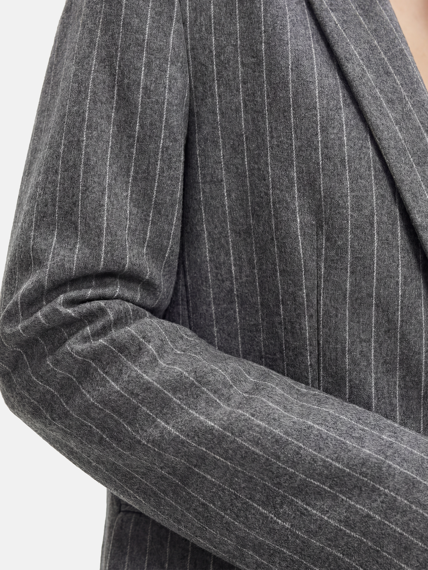 SELVANE Pinstripe Wool Blazer, longline with softened peak lapel and single-button front, tailored for a calm, vertical silhouette.