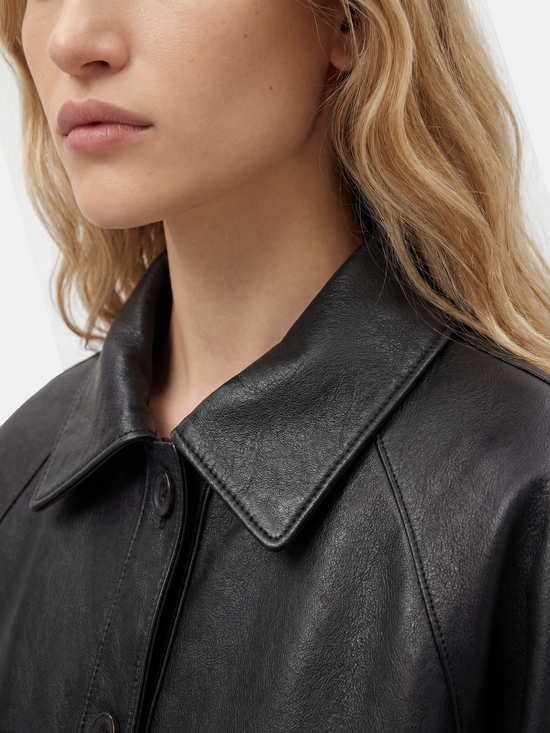 SELVANE deep black lambskin button bomber, cropped silhouette with ribbed hem and oversized patch pockets.