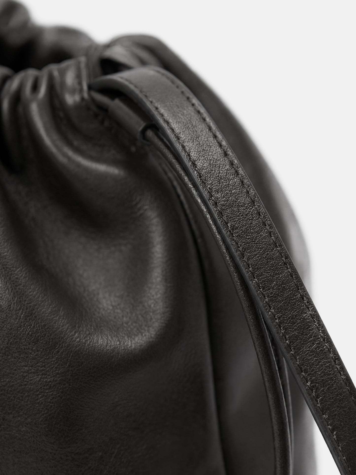 SELVANE soft drawstring pouch bag in a gentle, rounded silhouette with gathered top and secure strap.