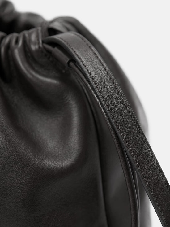 SELVANE soft drawstring pouch bag in a gentle, rounded silhouette with gathered top and secure strap.