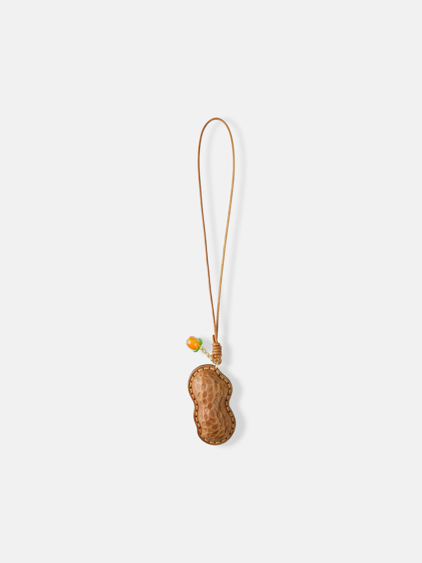 Selvane Peanut Pod Bag Charm, a sculpted leather peanut silhouette with contrast stitching, attached to a slim strap.