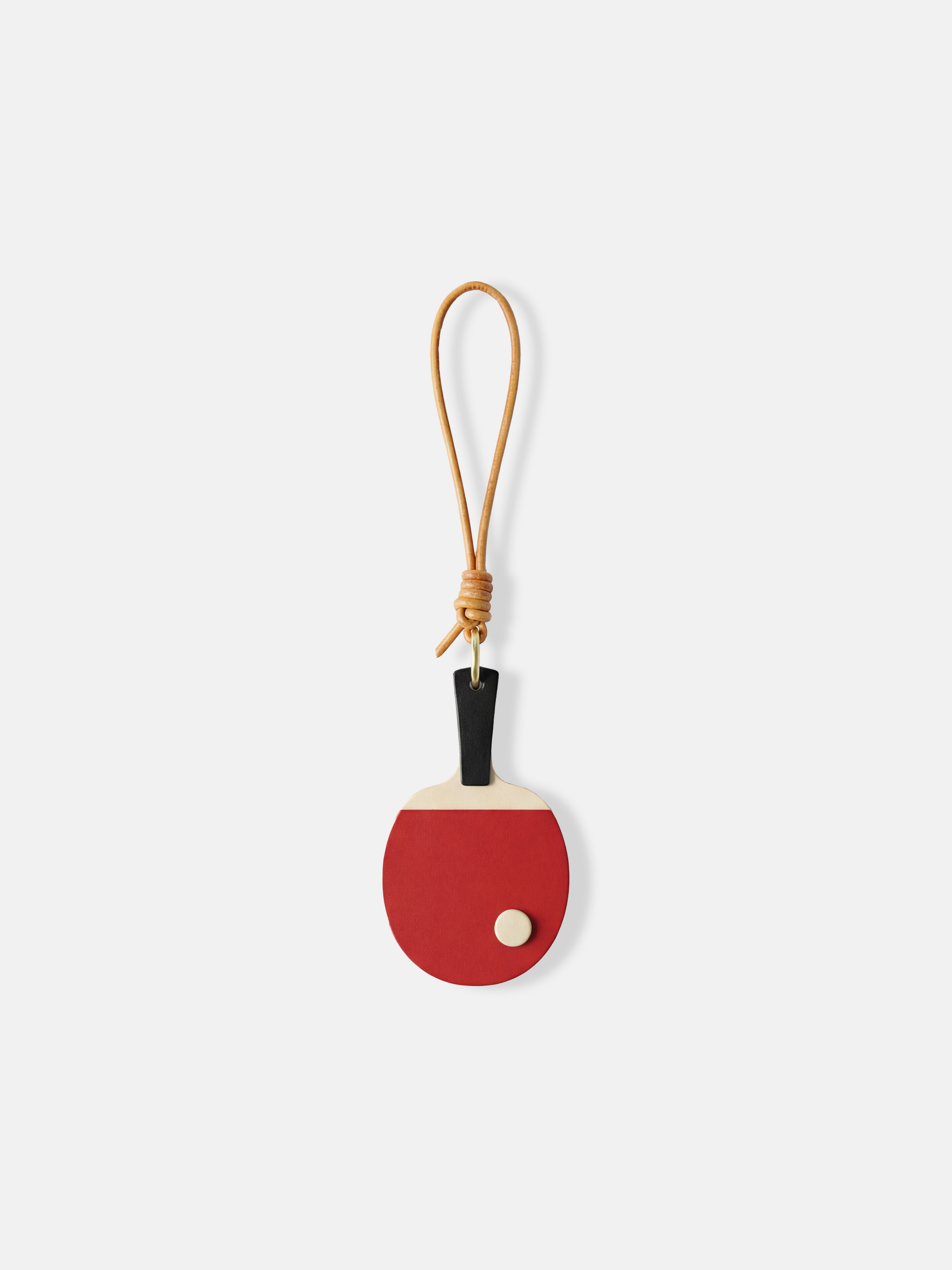 SELVANE Ping Pong Racket Bag Charm in bold red enamel, minimalist design with slim handle, long loop, and raised 'ball' detail.