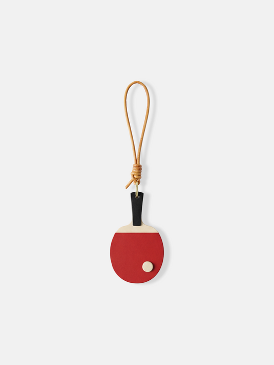 SELVANE Ping Pong Racket Bag Charm in bold red enamel, minimalist design with slim handle, long loop, and raised 'ball' detail.