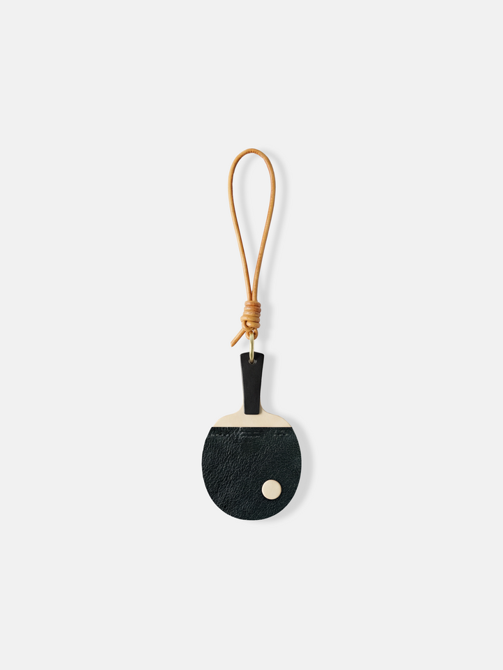 SELVANE Ping Pong Racket Bag Charm in bold red enamel, minimalist design with slim handle, long loop, and raised 'ball' detail.