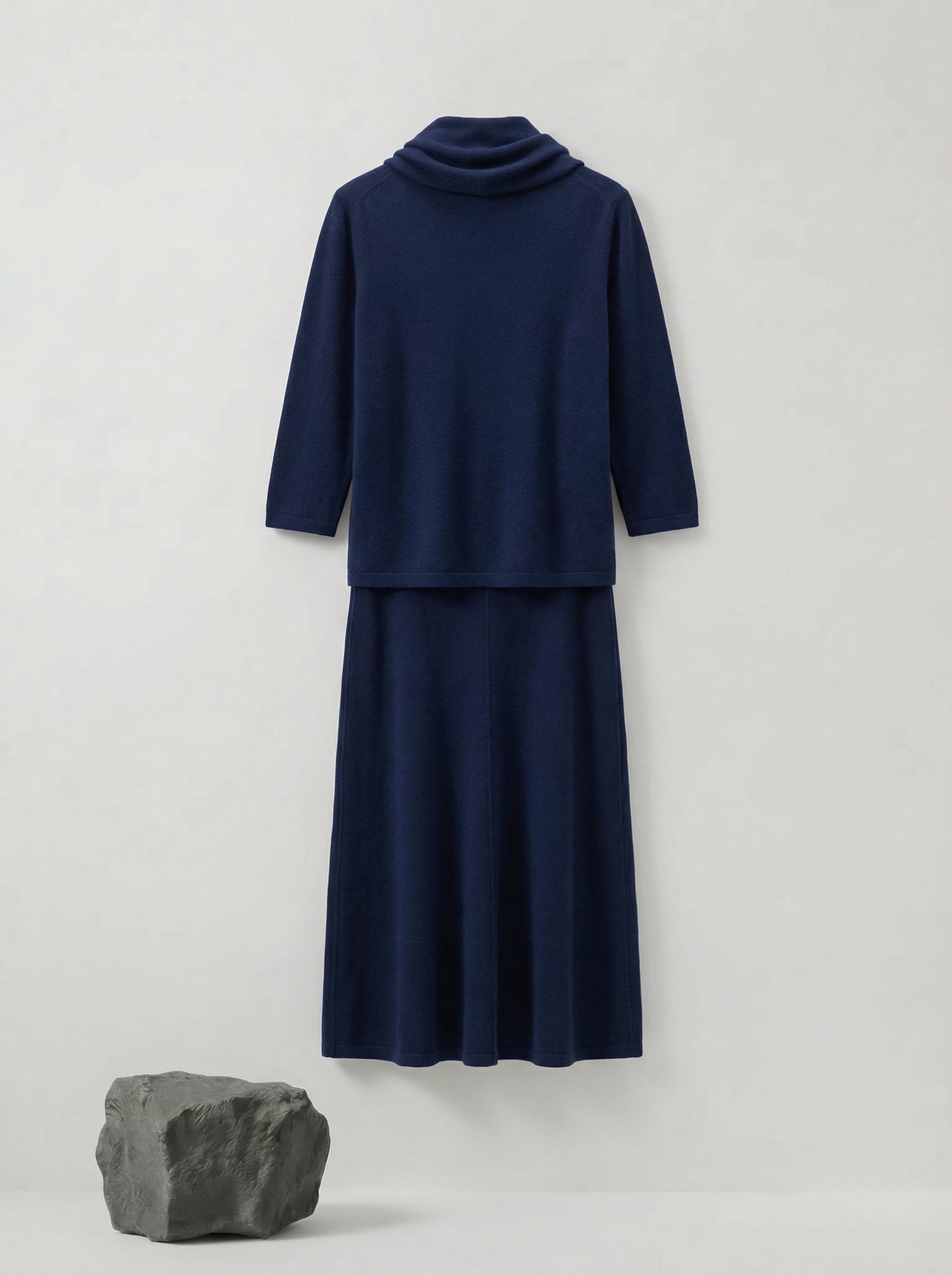 Model wearing a deep navy Tencel-blend cowl-neck top and matching midi pencil skirt set, styled elegantly.