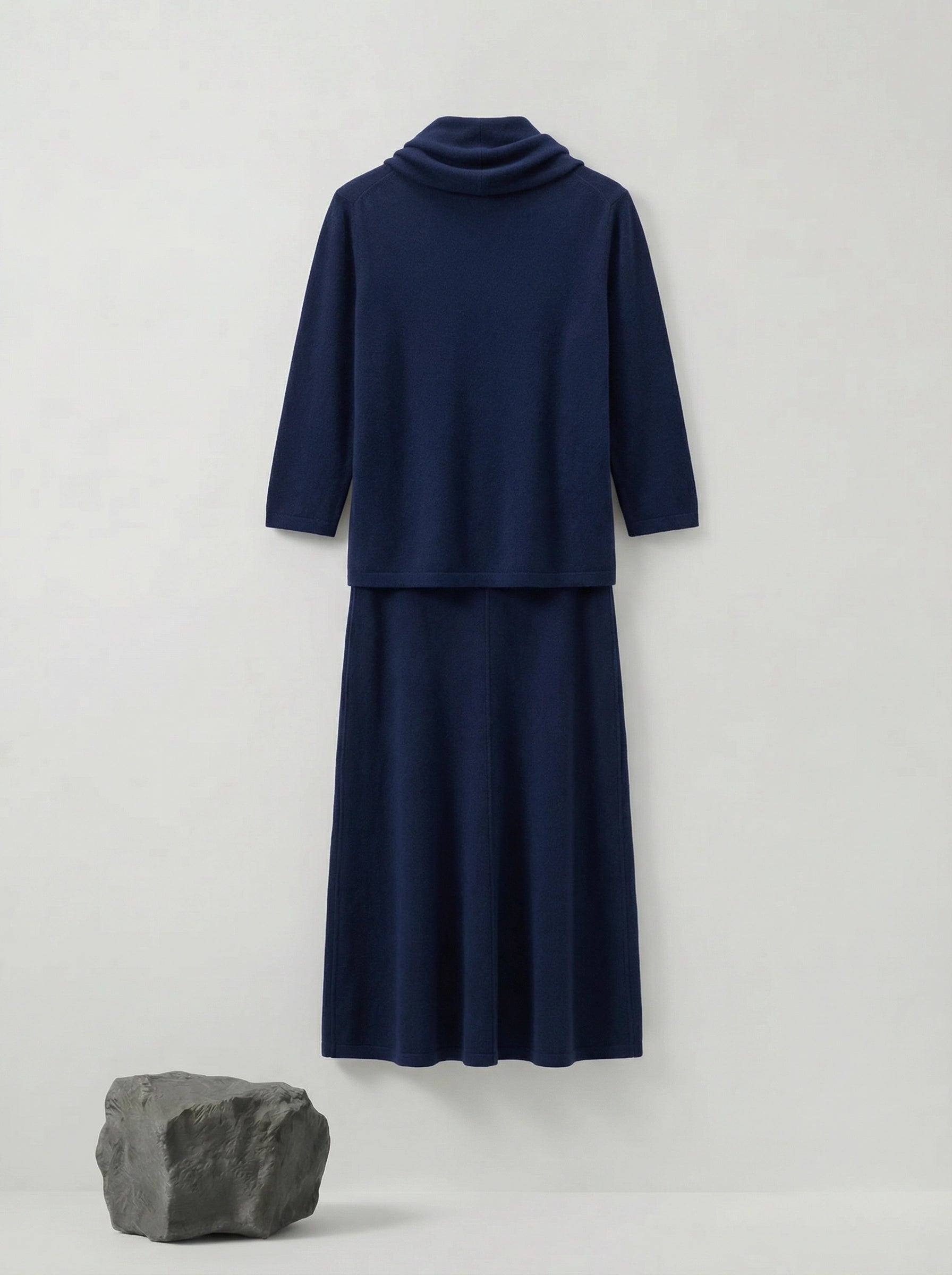 Model wearing a deep navy Tencel-blend cowl-neck top and matching midi pencil skirt set, styled elegantly.