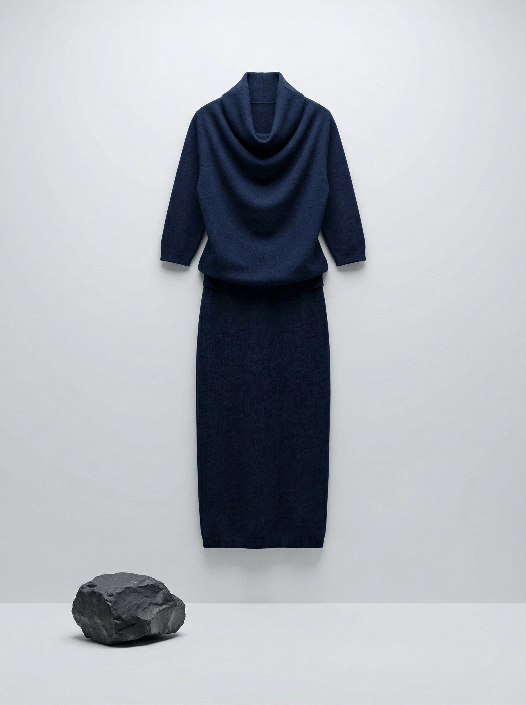 Model wearing a deep navy Tencel-blend cowl-neck top and matching midi pencil skirt set, styled elegantly.
