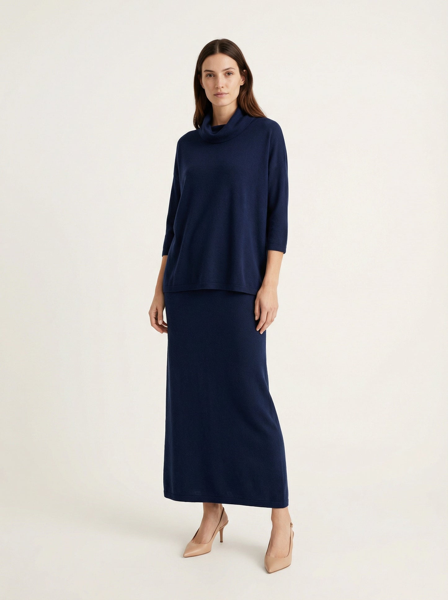 Model wearing a deep navy Tencel-blend cowl-neck top and matching midi pencil skirt set, styled elegantly.