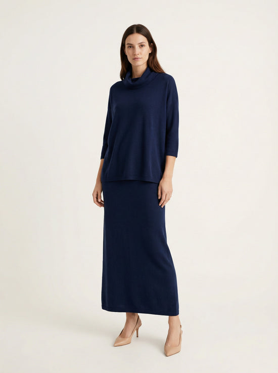 Model wearing a deep navy Tencel-blend cowl-neck top and matching midi pencil skirt set, styled elegantly.