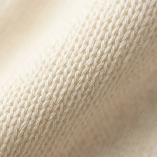 SELVANE warm ivory cowl-neck halter top, featuring architectural drape, semi-sheer fine-gauge knit, and relaxed body-skimming silhouette.