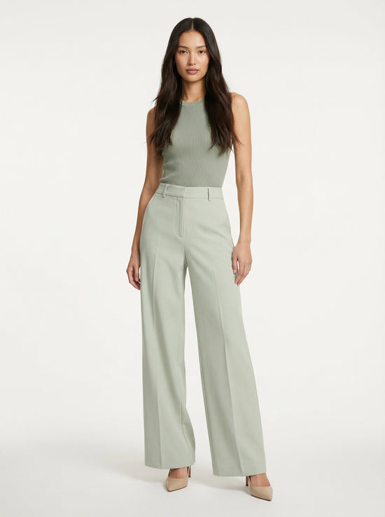 Model wearing SELVANE sage green ribbed knit tank and high-waisted wide-leg trousers set, standing elegantly.